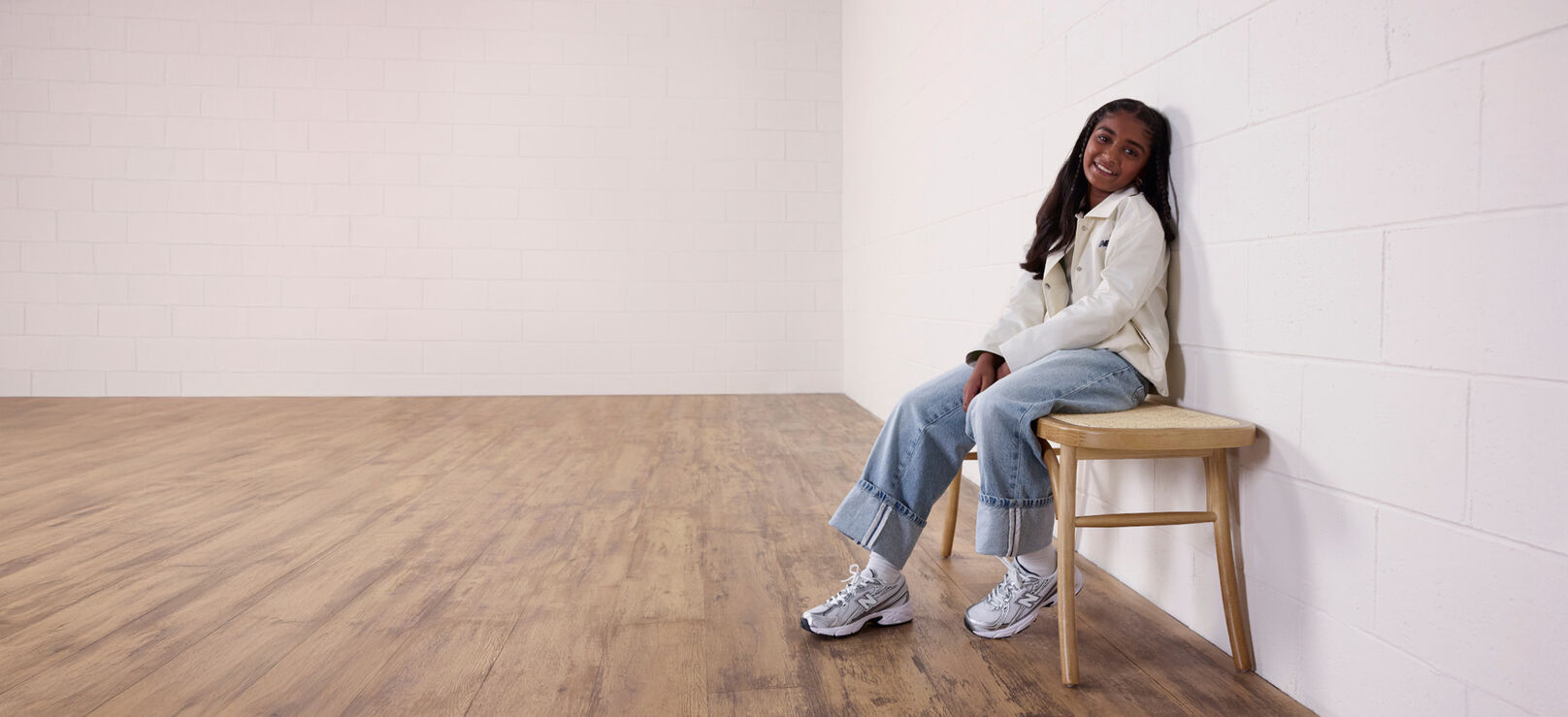 Girl sitting on wooden stool, wearing the 740 